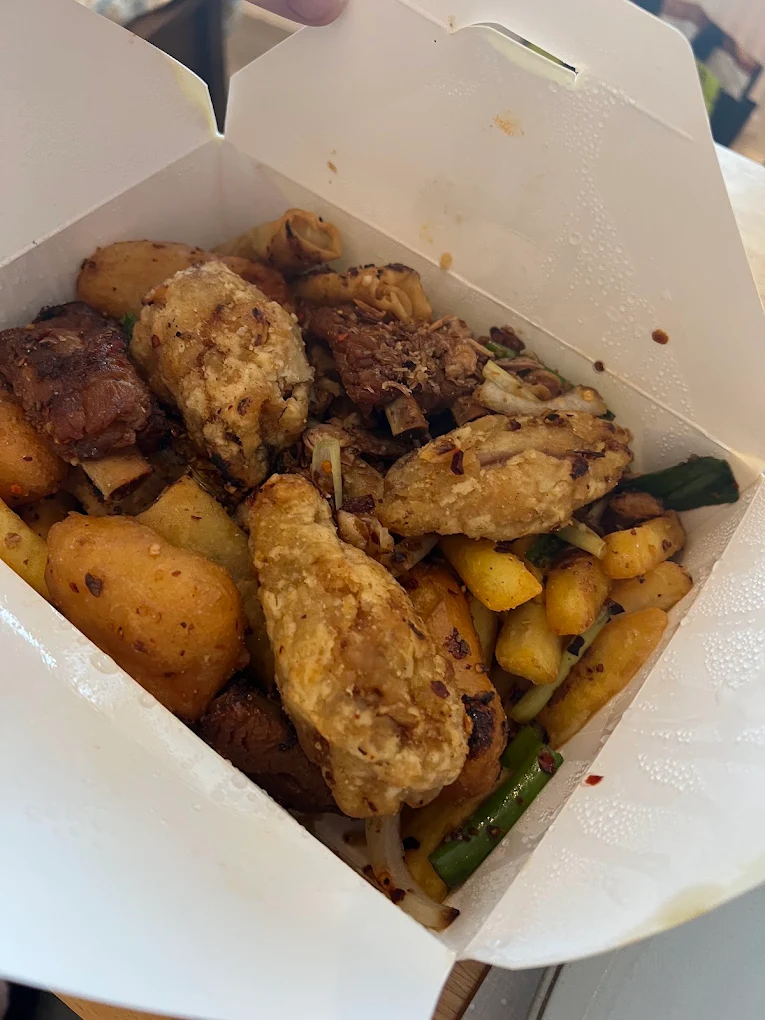 Salt and pepper chicken with pineapple in a takeaway box